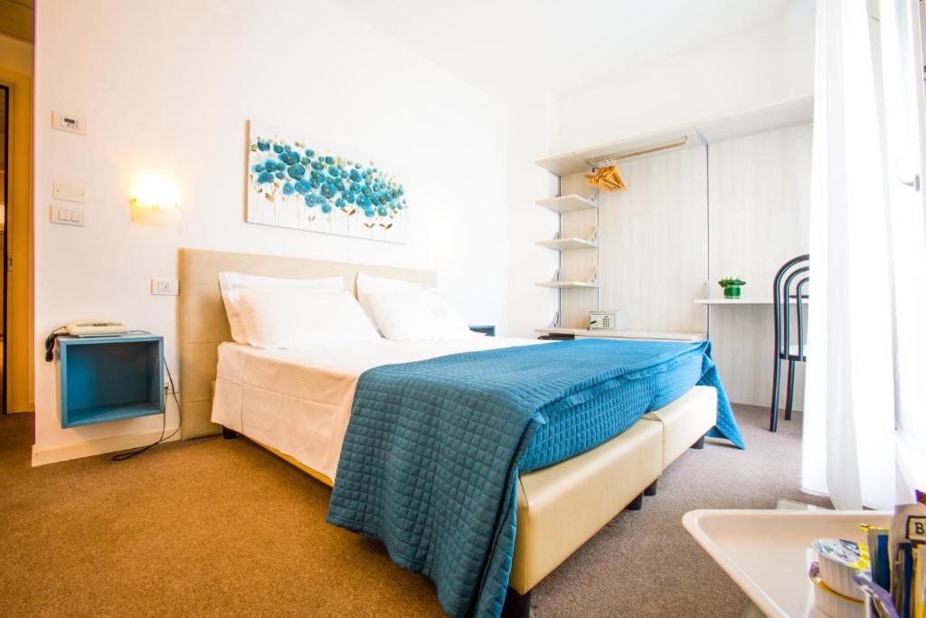 1 dormitorio con 1 cama y TV en Hotel Villa Anthea en Garda