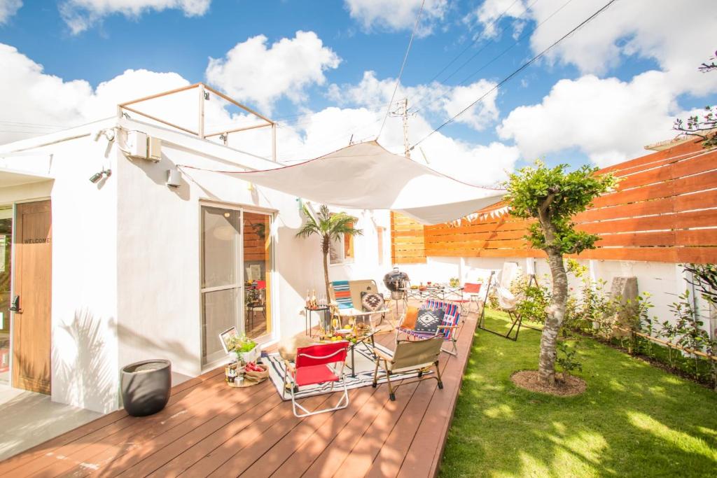 una terrazza con tavolo, sedie e ombrellone di Okinawa - House / Vacation STAY 44500 a Città di Okinawa