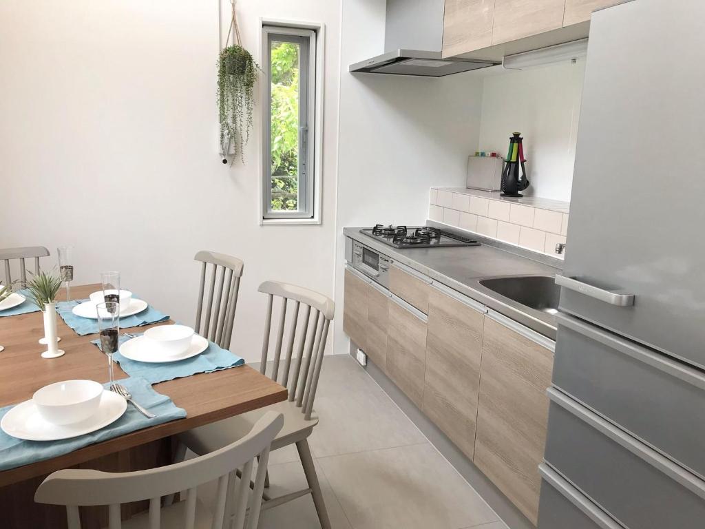a kitchen with a wooden table and a dining room at Nakagami-gun - House / Vacation STAY 45165 in Yomitan