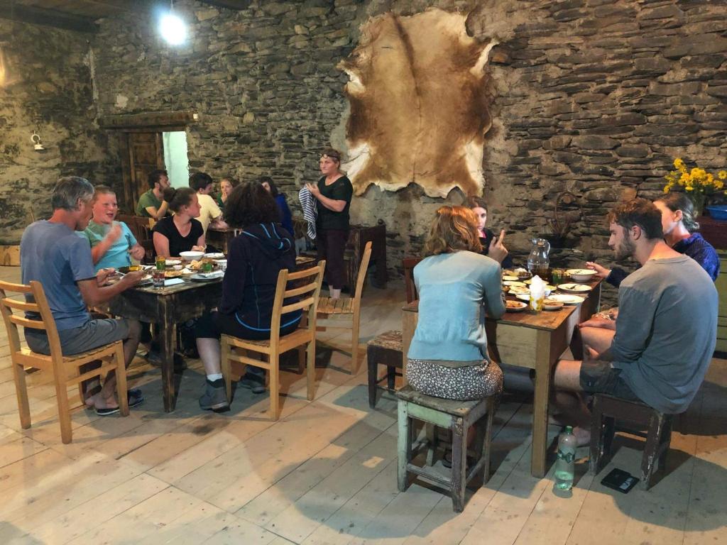 a group of people sitting at tables in a restaurant at Raul Lushnu Darbaz in Mestia