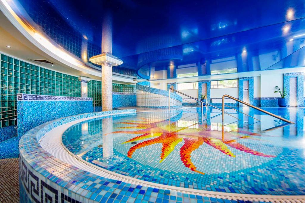 a swimming pool in a building with blue tiles at Haffner Hotel & SPA Sopot - Destigo Hotels in Sopot