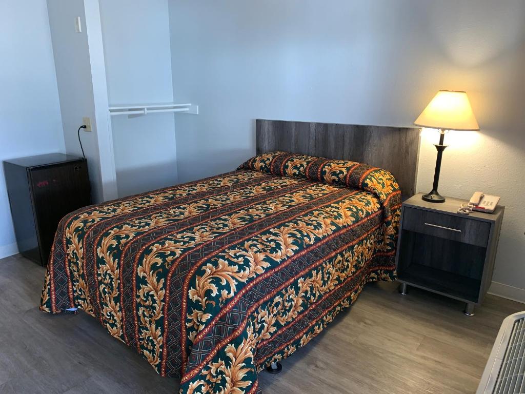 Una habitación de hotel con una cama con una manta. en EZ 8 Motel Old Town en San Diego