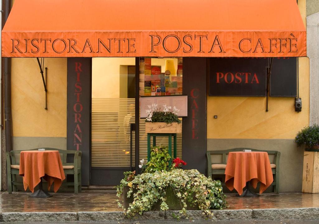 ein Restaurant mit Tischen und Stühlen davor in der Unterkunft Sopra Il Posta in SantʼOmobono Imagna