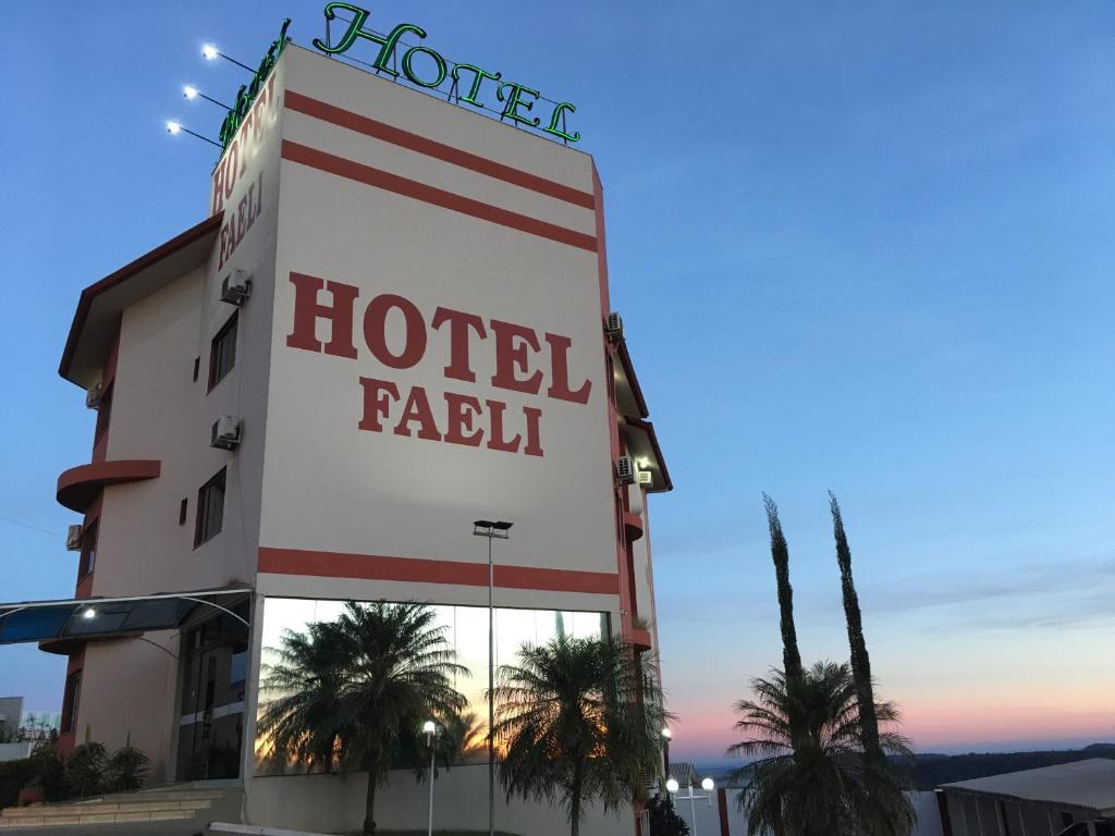 a hotel sign in front of a building at Hotel Faeli in Matelândia