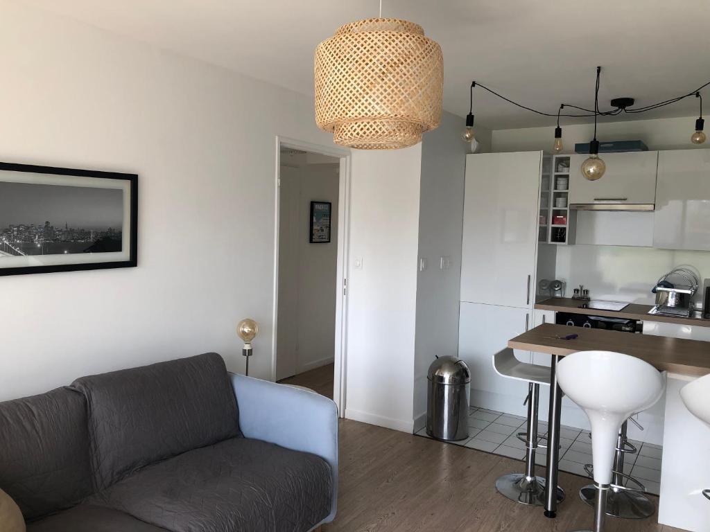 ein Wohnzimmer mit einem Sofa und einer Küche in der Unterkunft Le grand Bleu in Wimereux