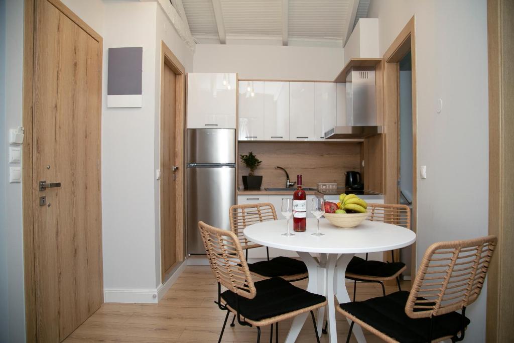 una pequeña cocina con mesa blanca y sillas en Foxnest Rest Villa Corfu, en Kanálion