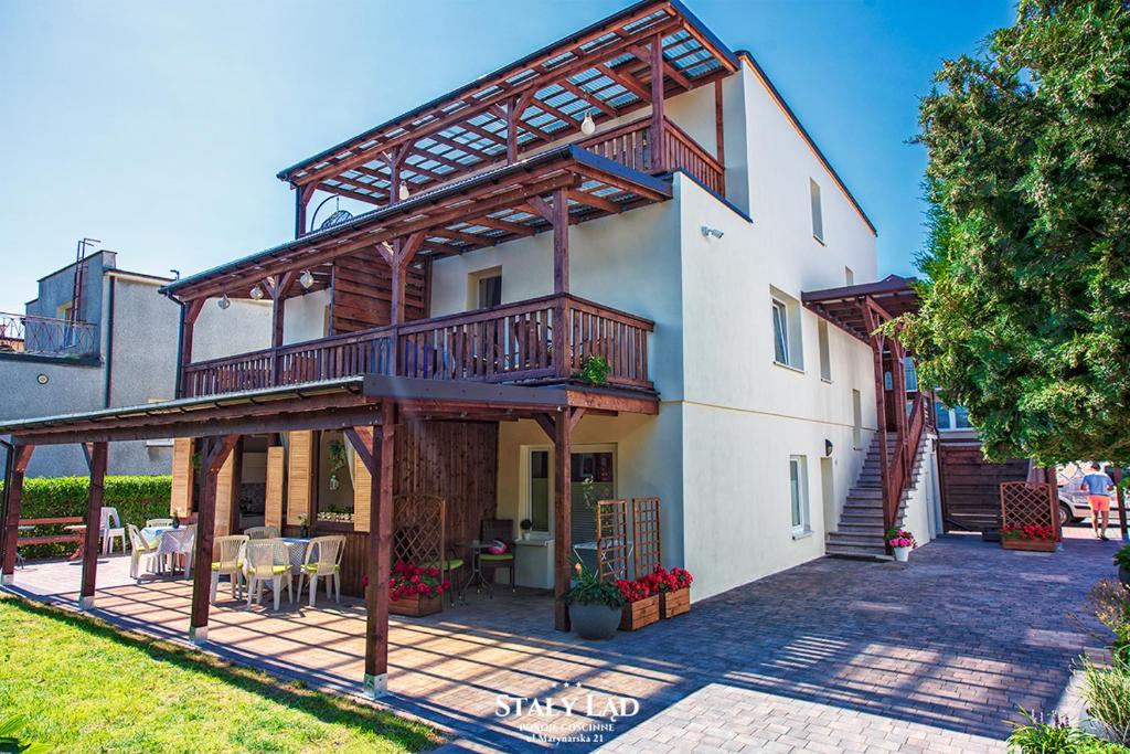 a house with a balcony and a patio at Stały Ląd in Darłowo