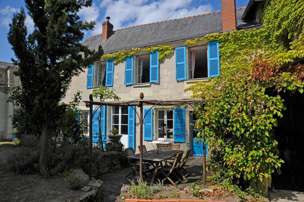 a blue house with a picnic table in front of it at The Secret Gem or The Hidden Gem or BOTH together in Montreuil-Bellay