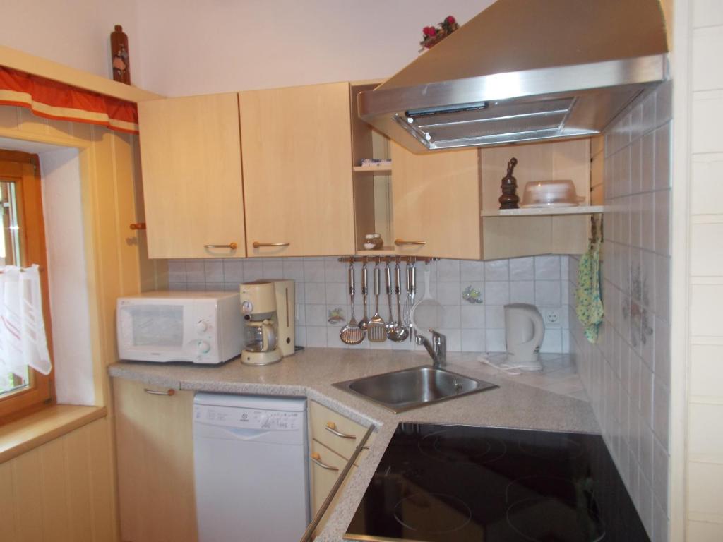 a small kitchen with a sink and a microwave at Haus Waldruh in Niederau