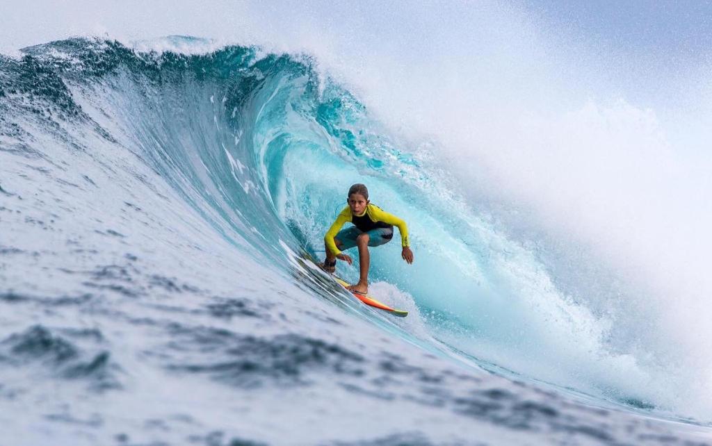 a person riding a wave on a surfboard in the ocean at Molar Wave in Himmafushi