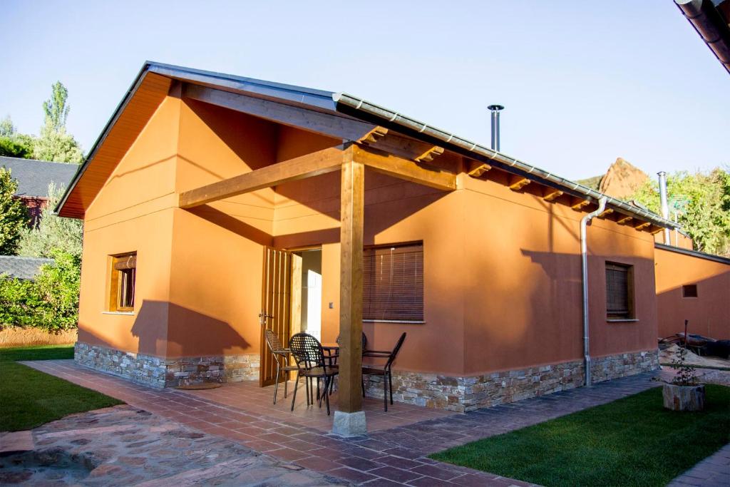 ラス・メドゥラスにあるLares · Cabañas Ruralesのパティオ(テーブル、椅子付)が備わる家です。