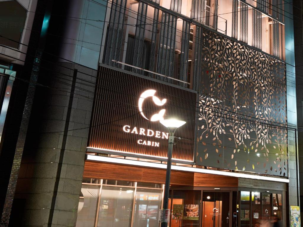 a building with a sign for a garden clinic at Gardens Cabin in Sapporo