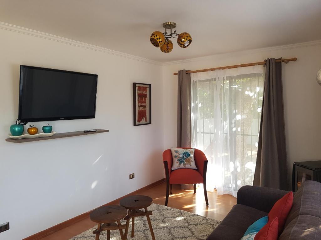 ein Wohnzimmer mit einem Sofa und einem TV an der Wand in der Unterkunft Apartamento La Calera in La Calera