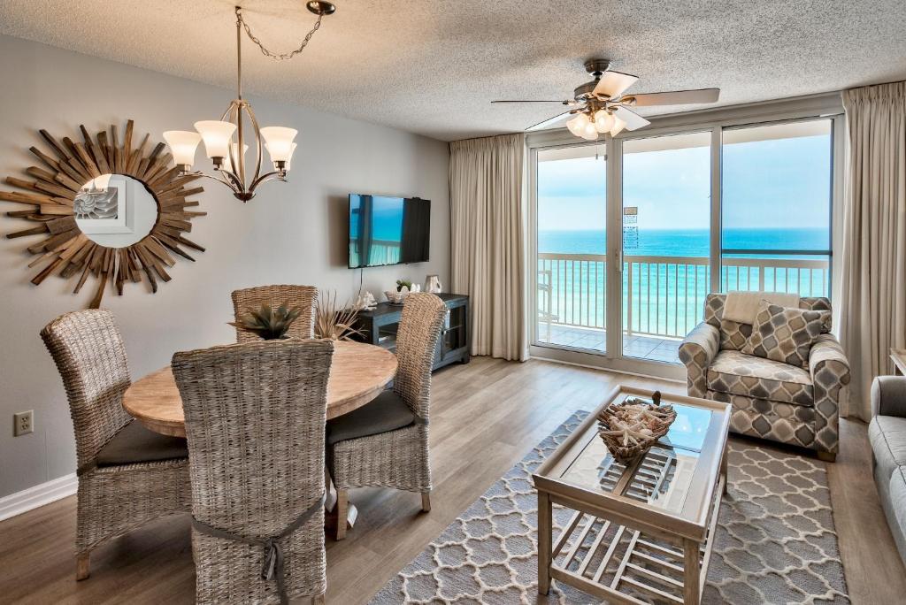 a living room with a dining room table and a view of the ocean at Pelican Beach Resort Destin in Destin