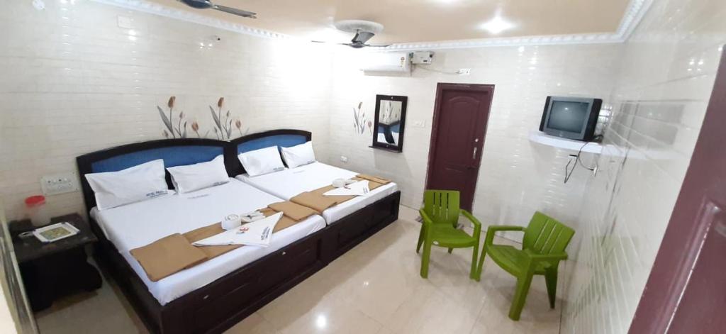 a bedroom with a bed and a table and a tv at Hotel Prakash in Rāmeswaram