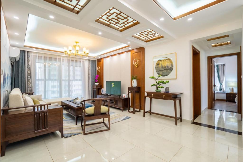 Zhengzhou Zhengdong New District·East University City· في تشنغتشو: غرفة معيشة مع أريكة وطاولة
