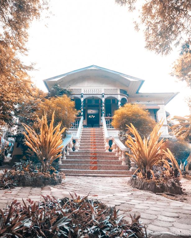 a house with stairs leading to the front door at Oasis Balili Heritage Lodge in Tagbilaran City