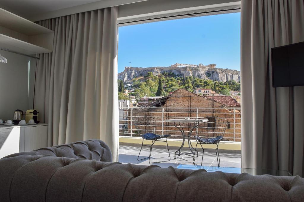 a living room with a couch and a large window at 24K Athena Suites in Athens