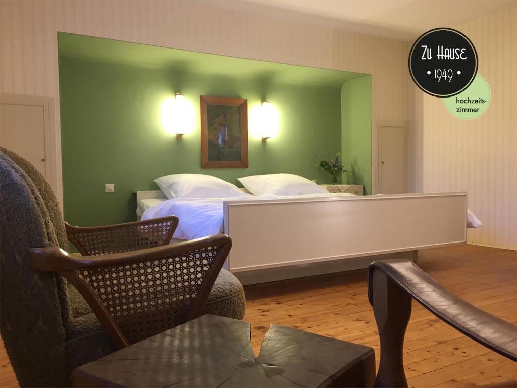 a bedroom with two beds and a green wall at Zu Hause 1949 in Markdorf