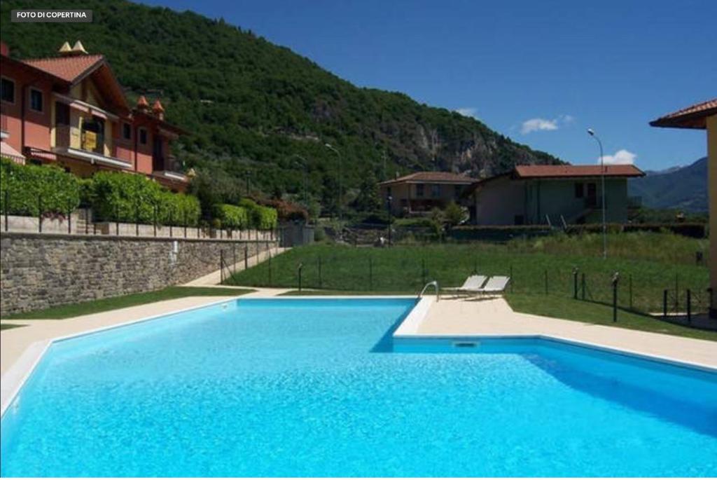 een groot blauw zwembad voor een huis bij Irina’s house with view on like and swimming pool in Riva di Solto