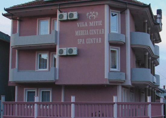a pink building with a sign on the side of it at HOTEL VILA MITIC LUXX SPA centar in Leskovac