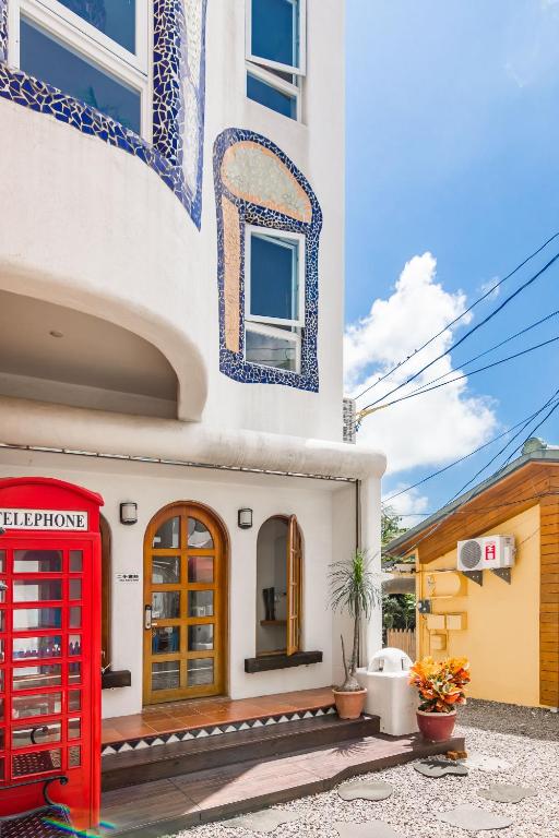 a red phone booth in front of a building at Fairyland &amp; Farm Guest House in Kenting