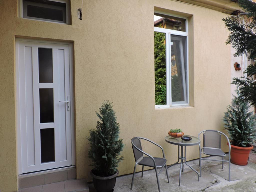 a patio with two chairs and a table and two windows at Old Town Apartament Oradea in Oradea