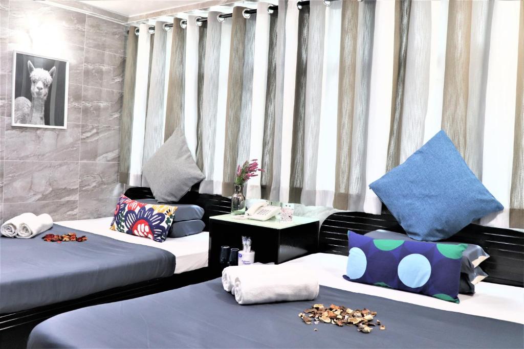 Habitación con 2 camas con almohadas y mesa. en W's Lounge en Hong Kong