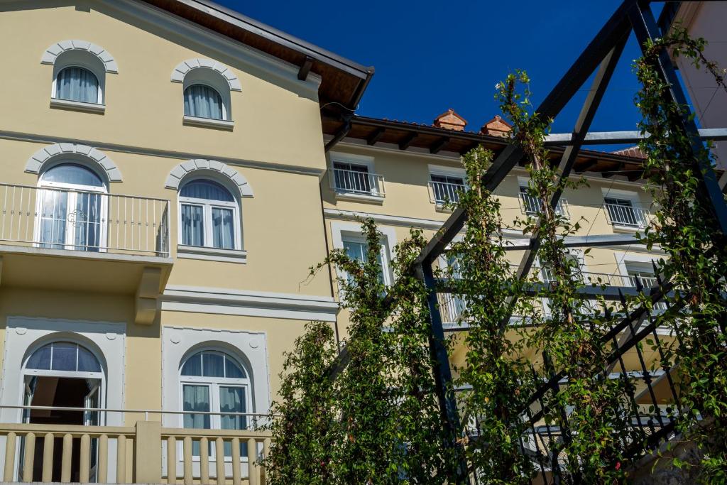 a large yellow building with white windows at Hotel Domino in Opatija