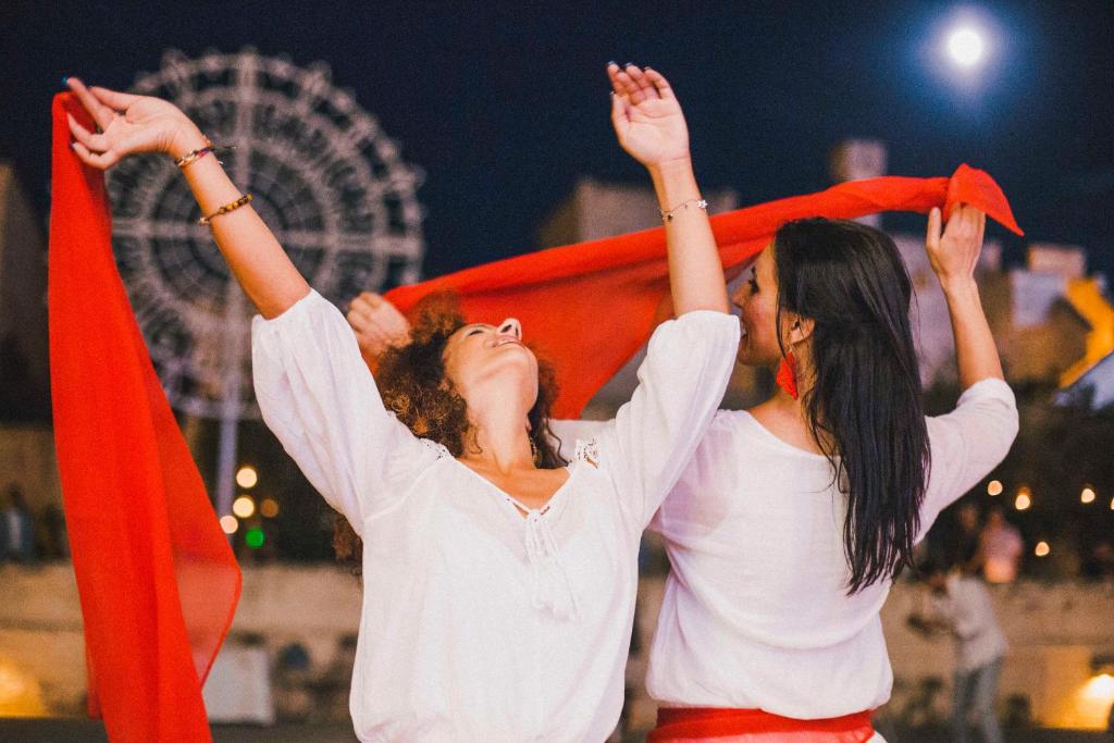 two women are holding up their hands in the air at Borgo Egnazia in Savelletri di Fasano