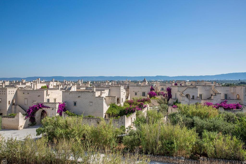 a view of a city with purple flowers at Borgo Egnazia in Savelletri di Fasano