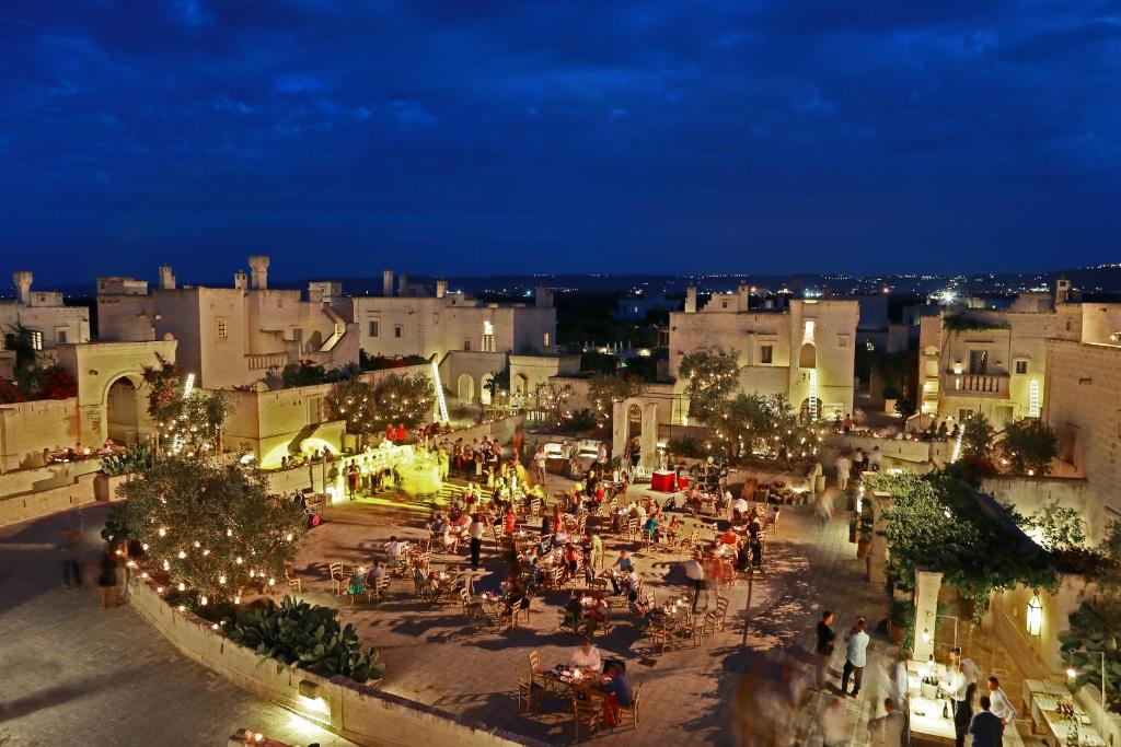 a group of people walking around a city at night at Borgo Egnazia in Savelletri di Fasano