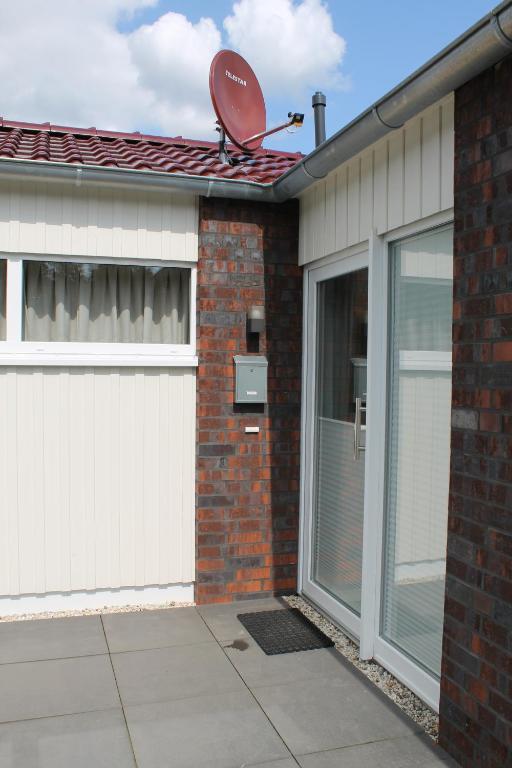 una casa con garaje con un satélite en la azotea en Ferienhaus am Quendorfer See Haus Nr.10, en Schüttorf