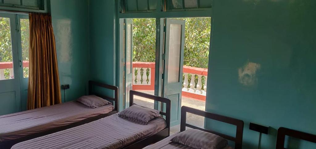 two beds in a room with blue walls and windows at Hebbar's Heritage Home in Mumbai