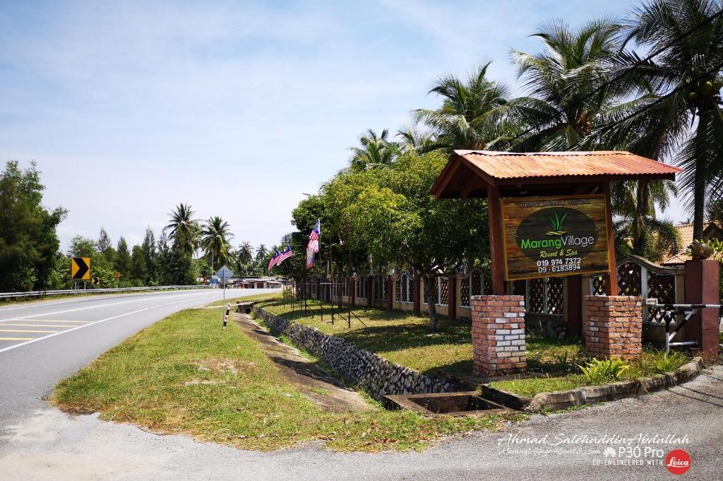 a sign on the side of a road at Marang Village Resort in Marang