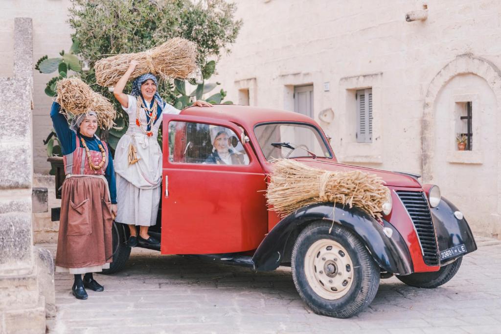 a group of people standing next to a red truck at Borgo Egnazia in Savelletri di Fasano