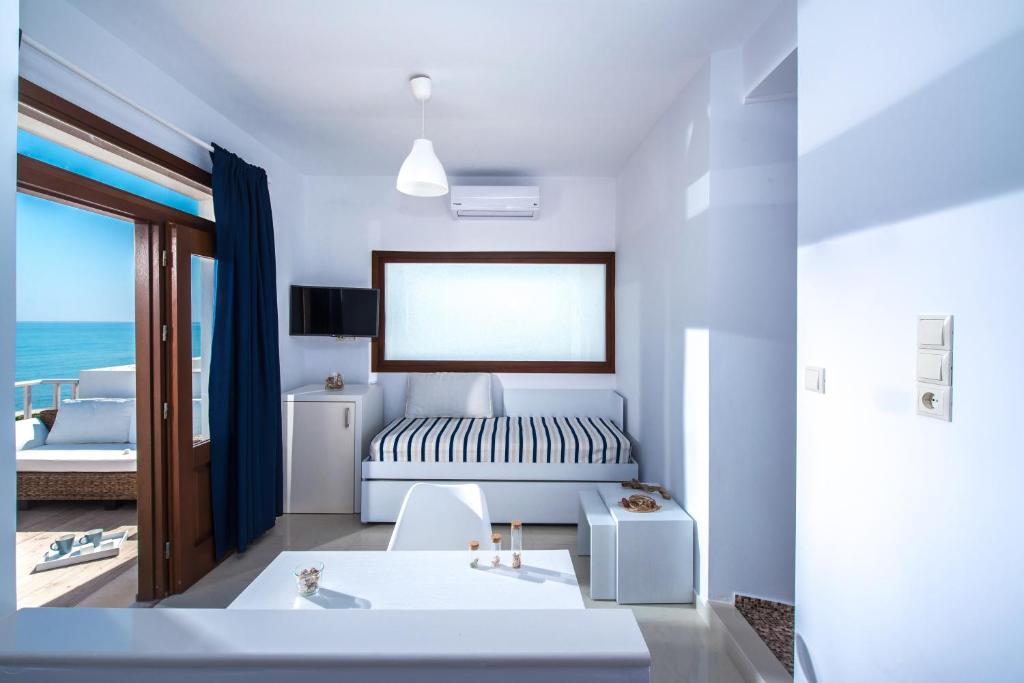 sypialnia z łóżkiem i widokiem na ocean w obiekcie Golden Grain Suites "by Checkin" w mieście Kokkini Hani