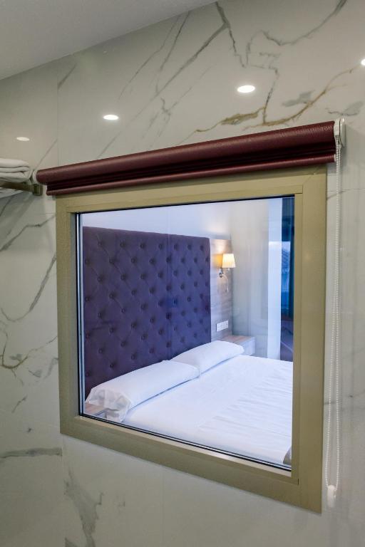 a glass window of a bedroom with a bed at Los Arcos in Nerja