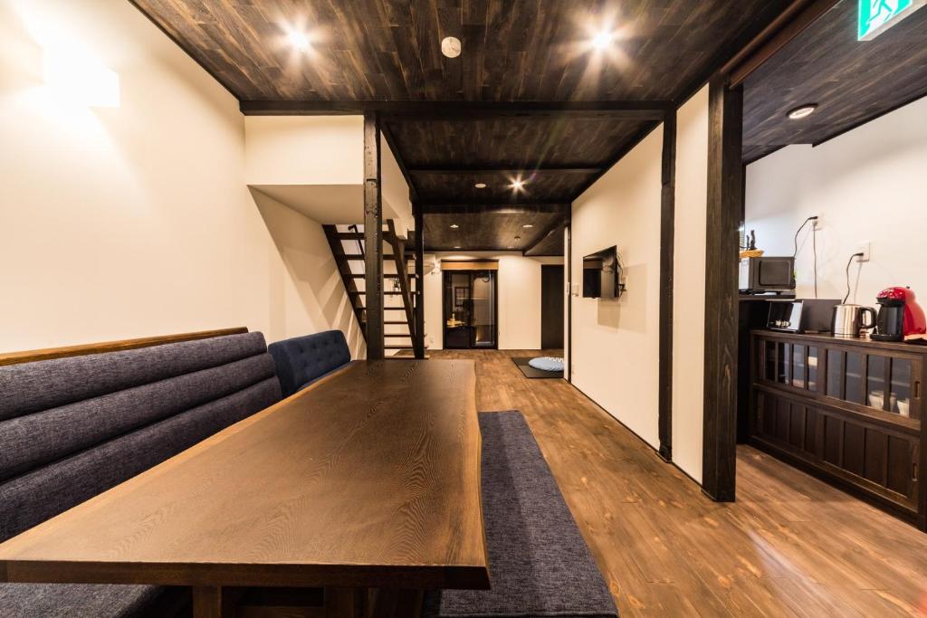 salon z drewnianym stołem i kanapą w obiekcie Kyotoya Tsukinoyu Mikeya-An w mieście Kioto