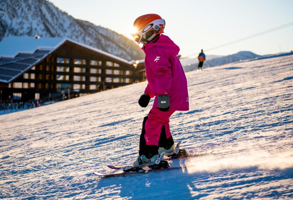 a young child is skiing down a snow covered slope at Myrkdalen Resort Hotel in Myrkdalen
