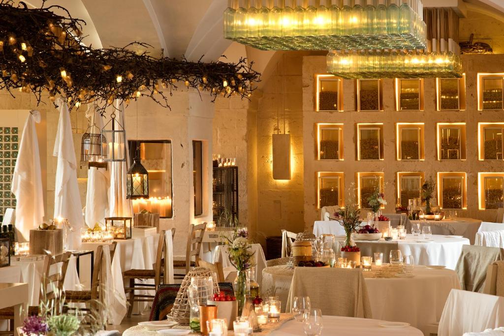 a dining room with white tables and chairs with lights at Borgo Egnazia in Savelletri di Fasano