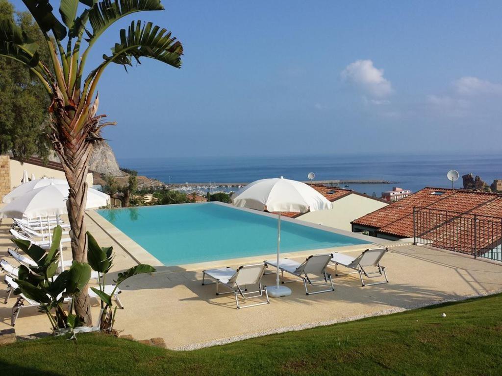 una piscina con sillas y vistas al océano en Residence Magarà, en Cefalú