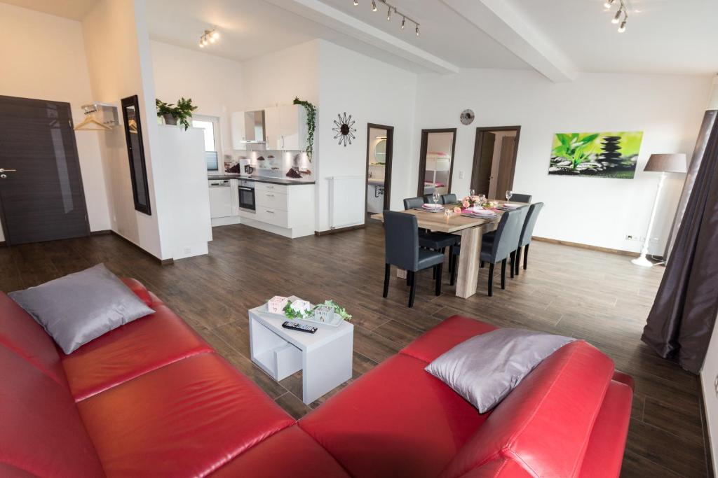 Una sala de estar con un sofá rojo y una mesa. en Ferienwohnung La Vita, en Winterberg