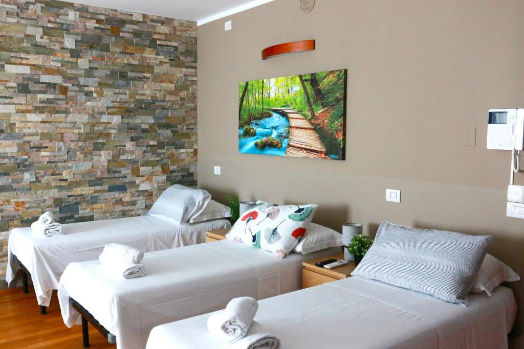 Zimmer mit 3 Betten und Wandgemälde in der Unterkunft Bnbook - Metropolitan Expo Flat in Rho