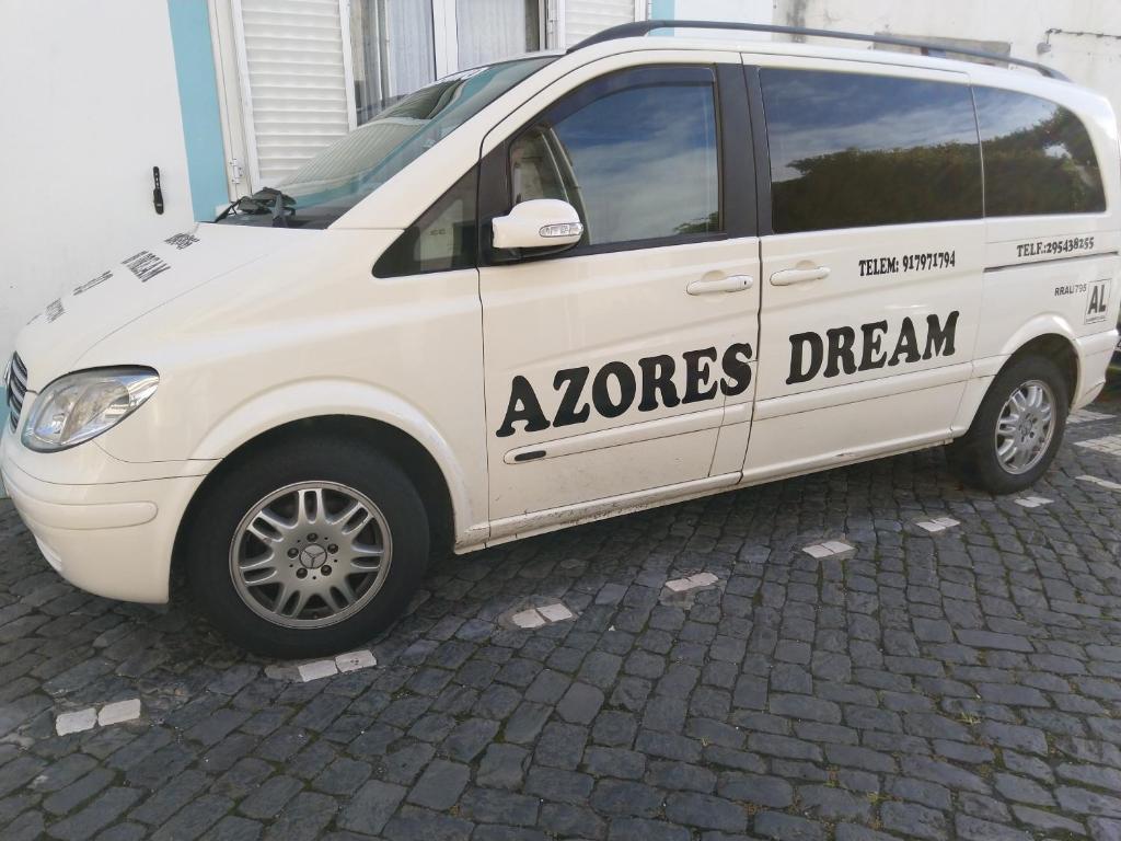 Una furgoneta blanca con un sueño de zonas escrito en ella en AzoresDream, en Velas