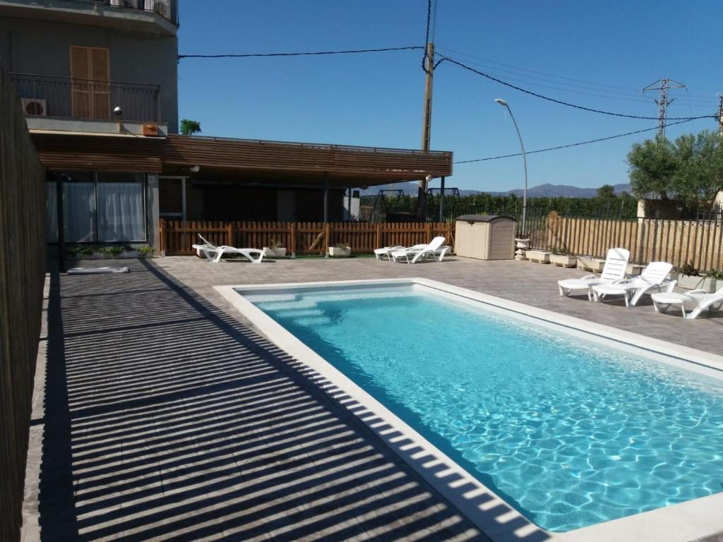 una piscina con sillas y una casa en La Masia, en Sant Pere Pescador