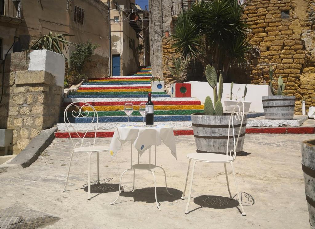 uma mesa com uma garrafa de vinho e duas cadeiras em 58 Gradini di Girgenti em Agrigento