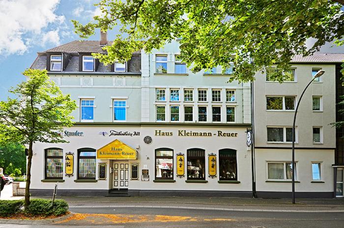 un grand bâtiment blanc avec un magasin devant lui dans l'établissement Hotel Haus Kleimann-Reuer, à Gladbeck