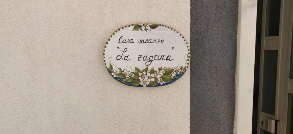 een bord met een bord op een muur met bloemen bij Casa Vacanze La Zagara in Marsala