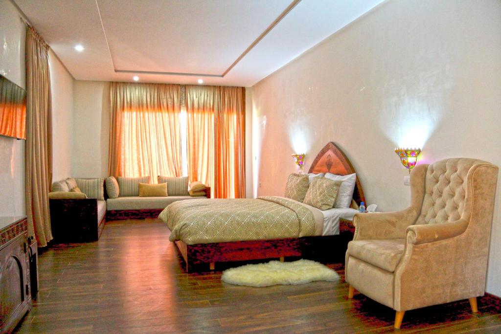 a bedroom with a bed and a chair and a couch at Dar Zayane in Khenifra